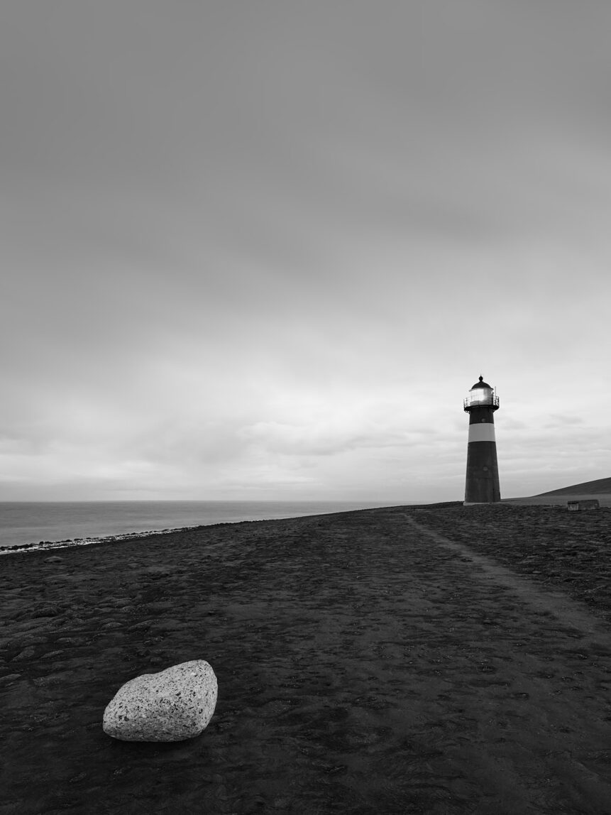 A rock and a lighthouse close to sunset at the North Sea coast in Westkapelle in Zeeland, The Netherlands. Guiding Light - Copyright 2019 Johan Peijnenburg - NiO Photography