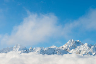 A winter mountain landscape, featuring the jagged peaks of the mountains of the Mont Blanc massif above a bank of clouds. Grand - Copyright Johan Peijnenburg - NiO Photography