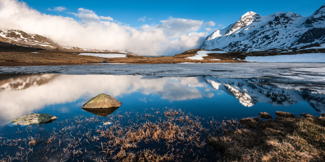 Alpine reflections in a half frozen alpine lake called Lej Pitschen (Bernina pass, Pontresina,  Switzerland), with the Piz Cambrena in the background. Alpine mountane lake at sunset - Copyright Johan Peijnenburg - NiO Photography