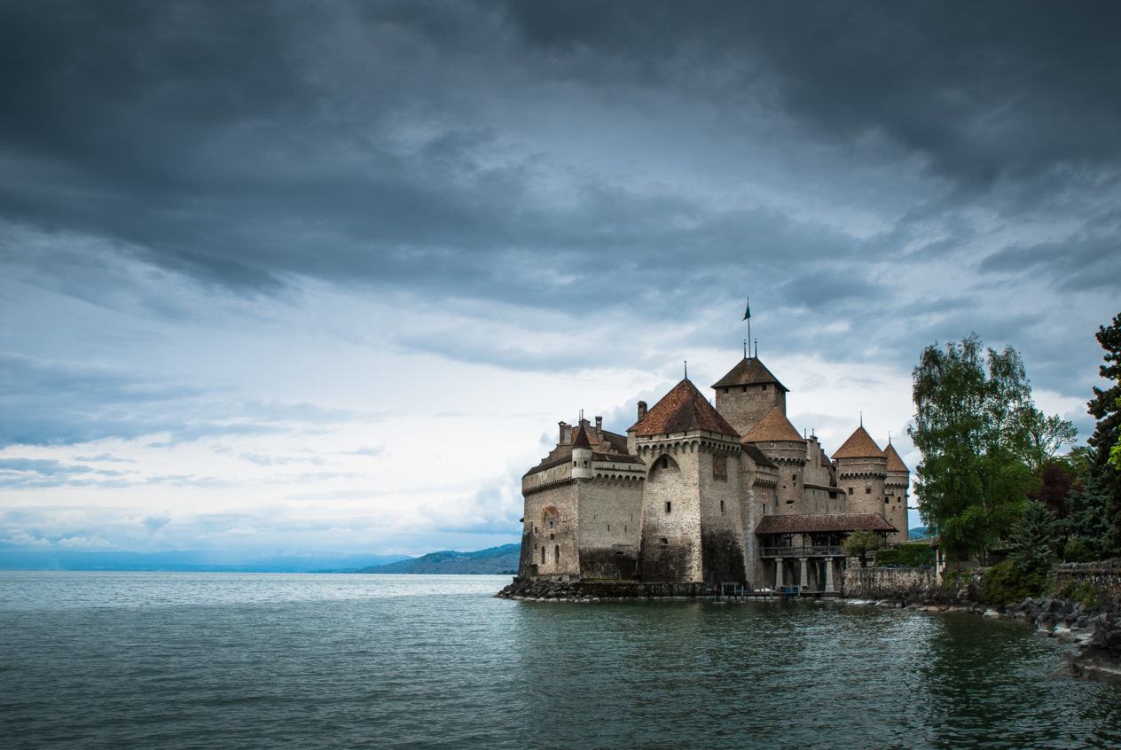 A lake landscape, featuring dark clouds above Château de Chillon and Lac Léman (Lake Geneva) near Montreux. Château de Chillon - Copyright Johan Peijnenburg - NiO Photography