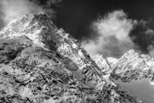 A Swiss mountain landscape in B&W, showing an alpine winter landscape with rising fog around the mountains of the Mont Blanc massif. Snowy Peaks - Copyright Johan Peijnenburg - NiO Photography