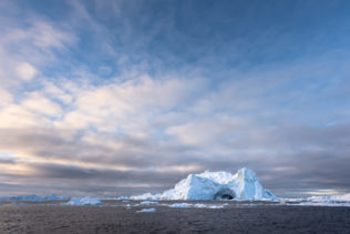 An Arctic coastal landscape showing icebergs close to sunset in the Ilulissat Icefjord near Disko Bay in Greenland. Temple of Ice - Copyright Johan Peijnenburg - NiO Photography