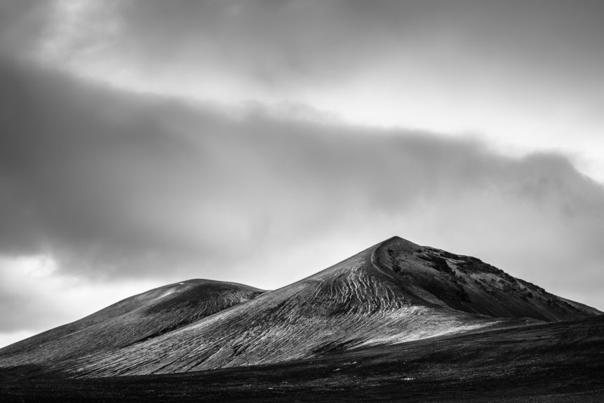 A minimalist Icelandic landscape in B&W, featuring the black sand and mountains of Landmannalaugar in the highlands of Iceland against a moody sky. Icelandic Curves - Copyright Johan Peijnenburg - NiO Photography