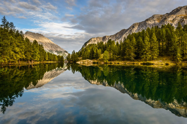 A tranquil sunrise at Lai da Palpuogna with Piz Ela mountain catching first light in the background. This Swiss alpine lake is located at the Albula Pass near Bergün in the canton of Graubünden. Alpine Serenity - Copyright Johan Peijnenburg - NiO Photography