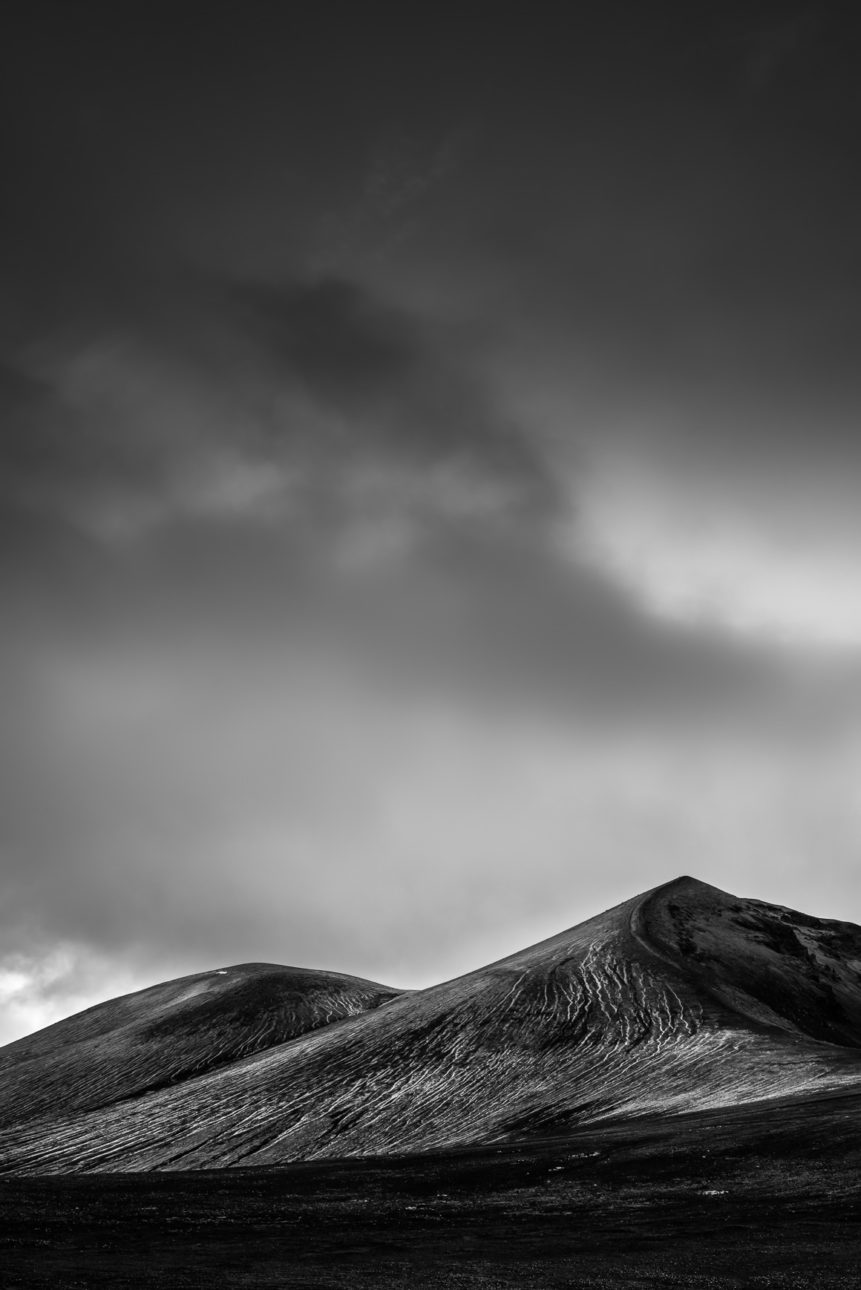 A fine art mountain landscape in B&W, featuring a foreboding sky above the eroded mountains of Landmannalaugar in the highlands of Iceland. Eroded - Copyright Johan Peijnenburg - NiO Photography