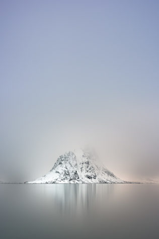 A Nordic coastal landscape, featuring Pantaliatinden mountain with snow and fog in the Kirkefjorden near Reine in Lofoten, Norway. Frozen Silence - Copyright Johan Peijnenburg - NiO Photography