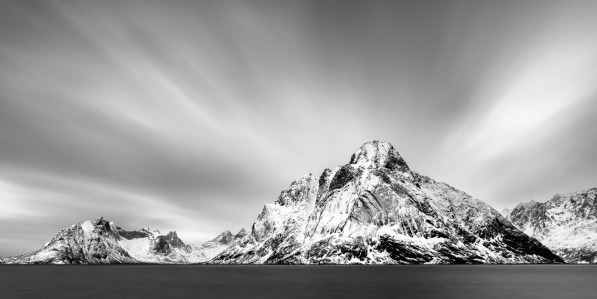 A fine art mountain landscape in black & white, featuring the coastal mountains of Lofoten along the Kirkefjorden near Reine in Norway. Striking - Copyright Johan Peijnenburg - NiO Photography