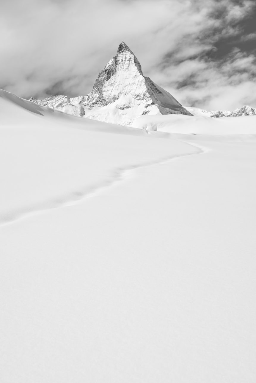 The Matterhorn (Cervino) in winter with a snow trail leading the eye towards the Matterhorn, in black & white. Standing Out - Copyright Johan Peijnenburg - NiO Photography