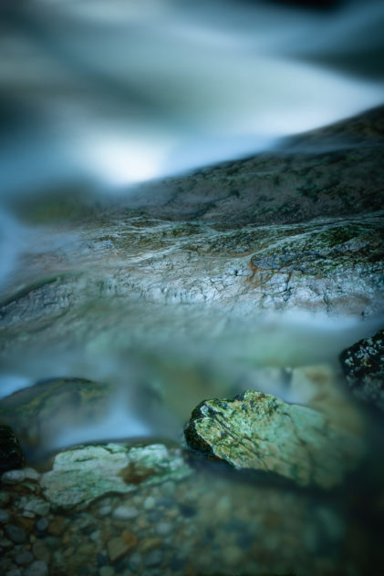 A long exposure photograph of flowing water and stones in a mountain river. Silky smooth water - Copyright Johan Peijnenburg - NiO Photography