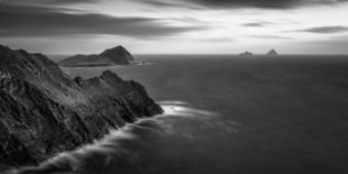 An Irish coastal landscape in B&W, showing the cliffs of Kerry and the Skellig Islands lit by the last light of sunset at the North Atlantic Ocean along the Ring of Kerry in Ireland. Last Light - Copyright Johan Peijnenburg - NiO Photography