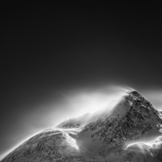 A mountain landscape in black & white, showing Piz Cambrena mountain in the Swiss Alps of Engadin enduring a snowstorm in winter. Furious - Copyright Johan Peijnenburg - NiO Photography