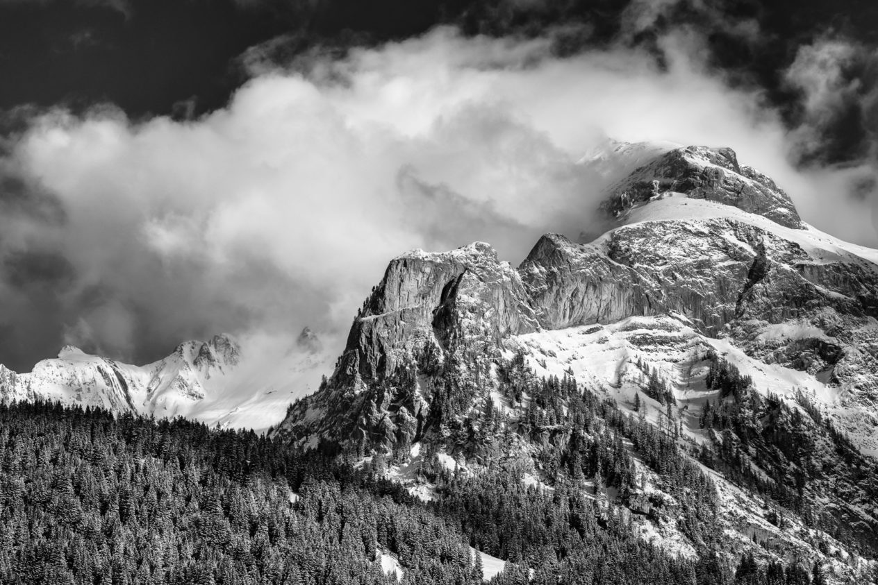 The Swiss Alps near Gsteig in B&W, with clearing fog above Spitzhorn mountain and an alpine forest in winter. Just Breathe - Copyright Johan Peijnenburg - NiO Photography