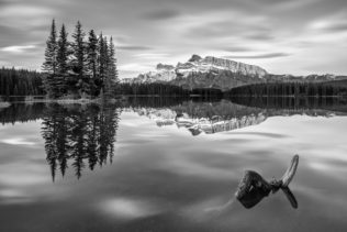 A lake landscape in B&W, featuring Two Jack Lake in Banff National Park, Canada, with Mount Rundle and trees reflected in the lake. Reflected - Copyright Johan Peijnenburg - NiO Photography