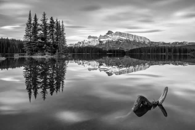 A lake landscape in B&W, featuring Two Jack Lake in Banff National Park, Canada, with Mount Rundle and trees reflected in the lake. Reflected - Copyright Johan Peijnenburg - NiO Photography