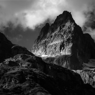 A landscape in black & white, showing clouds around the rugged peak of the Wendenhorn mountain in the Swiss Alps. Rugged - Copyright Johan Peijnenburg - NiO Photography